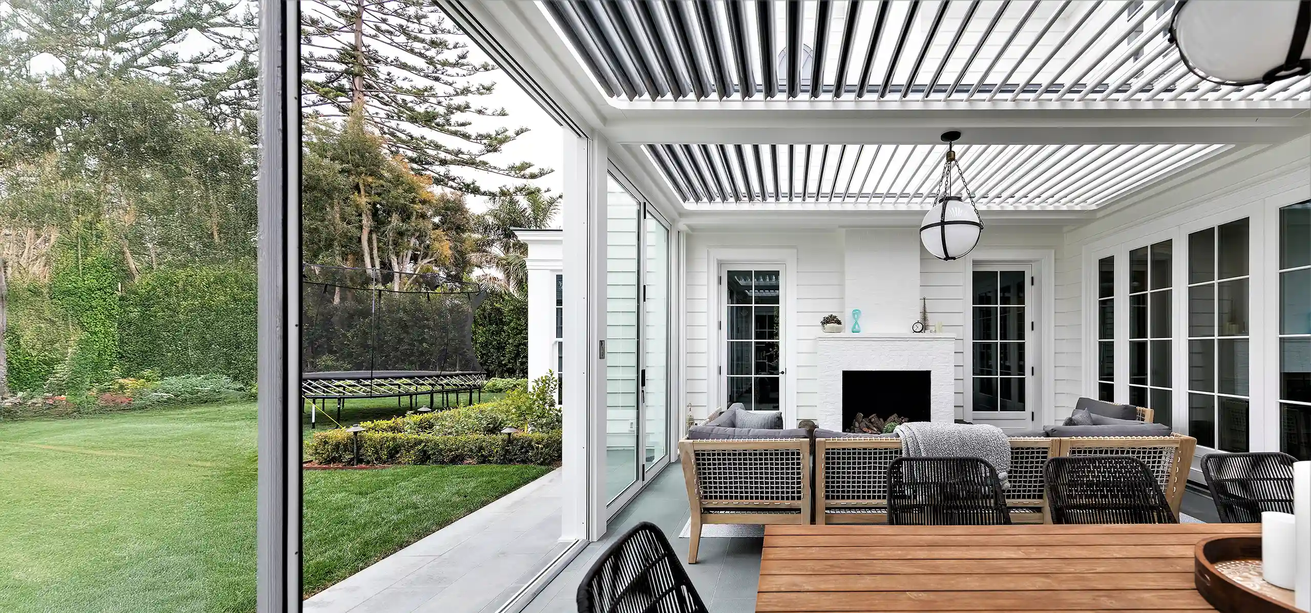 Photo a StruXure pergola providing cover for an outdoor dining area and outdoor living room.