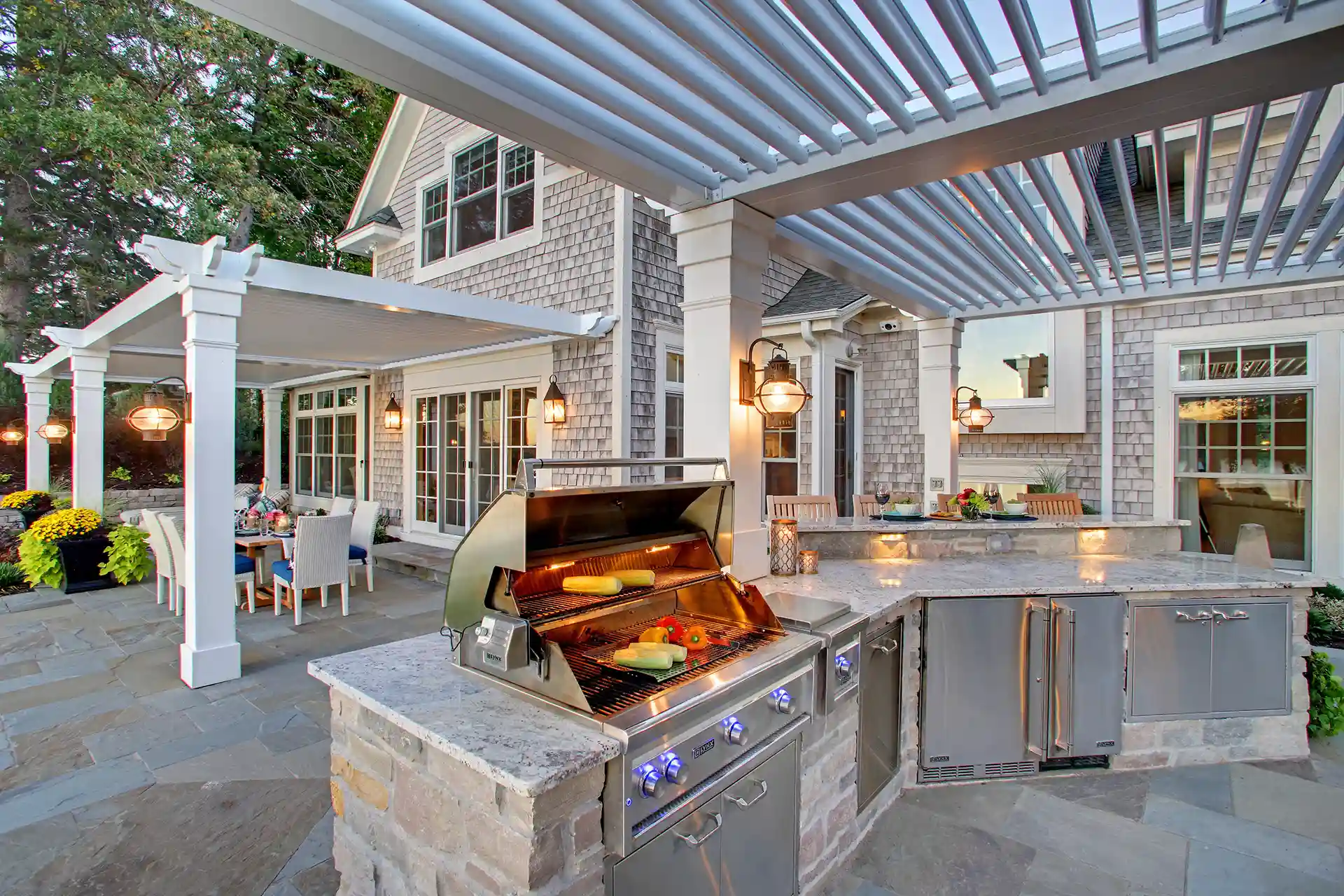 Photo of a louvered roof pergola system covering an outdoor kitchen and dining room.